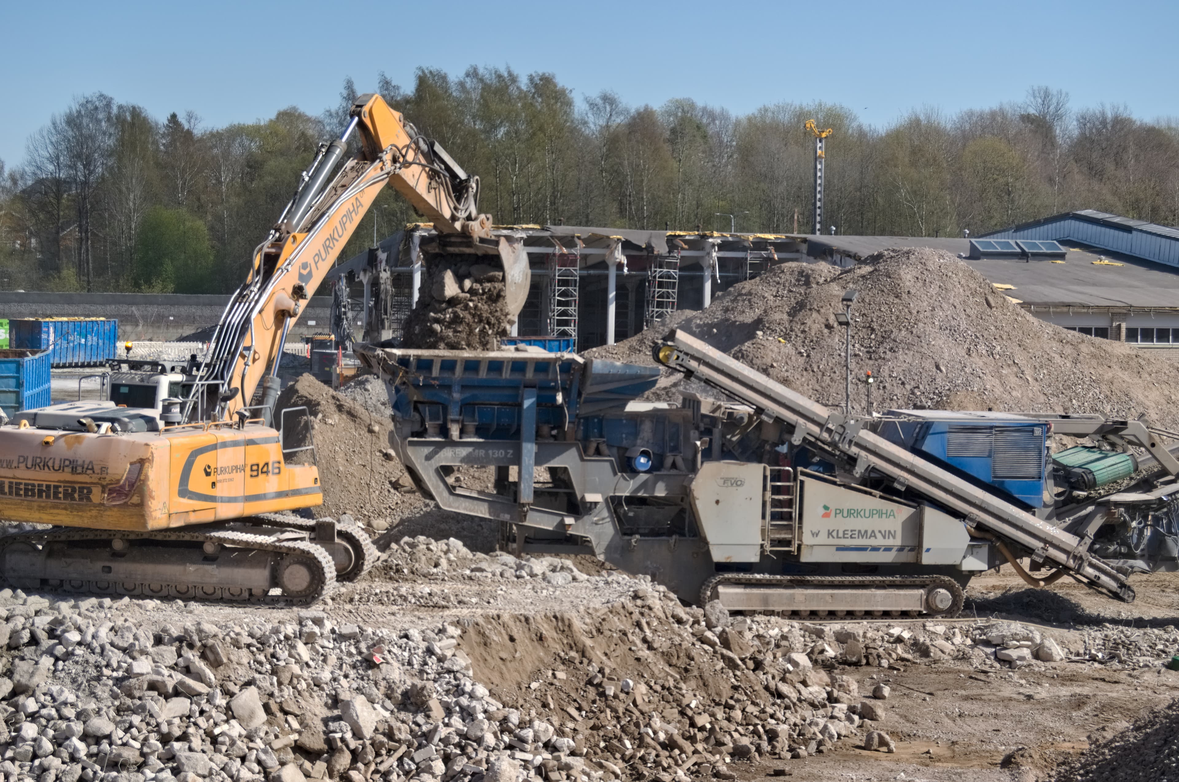 Excavator feeding a mobile crushing plant — illustrative industry photograph